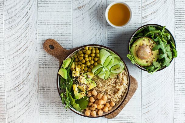 Egészséges zöldséges ebéd a Buddha tálból quinoával, avokádóval, csicseriborsóval, uborkával. Az egészséges étel koncepciója vegetáriánusok számára, trendi étel. Kiváló minőségű fénykép - Fotó, kép