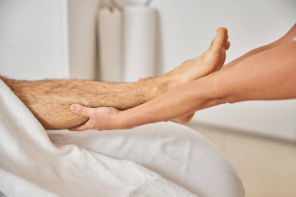 Young man receiving professional foot massage in spa salon - Foto, immagini