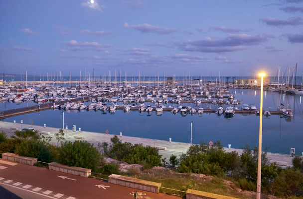 Италия, Сицилия, Средиземное море, Марина ди Рагуза (провинция Рагуза); лодки и роскошные яхты в порту на закате  - Фото, изображение