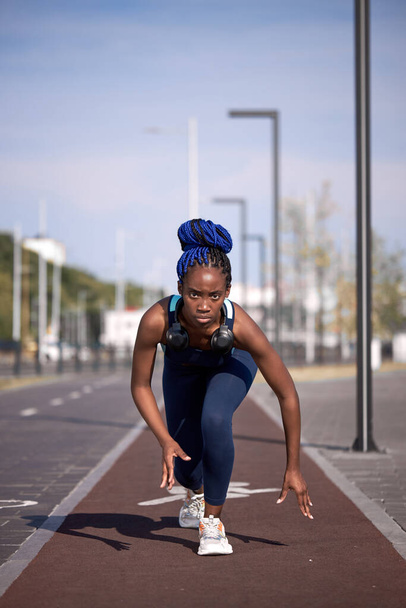 athletic african american girl stands at the start, about to run - Fotoğraf, Görsel
