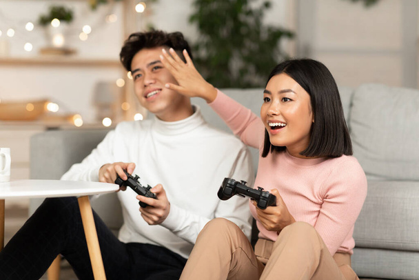 Japanese Spouses Playing Computer Games Sitting On Couch At Home - Photo, Image