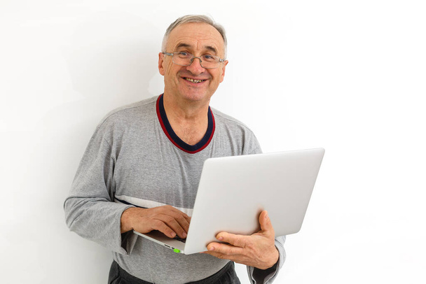 Uśmiechnięty staruszek z laptopem. Izolacja na białym tle - Zdjęcie, obraz