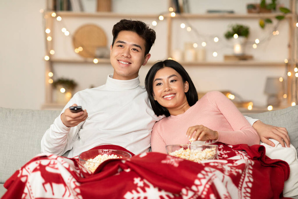 Asian Couple Watching Christmas Movies On TV Sitting At Home - Photo, Image