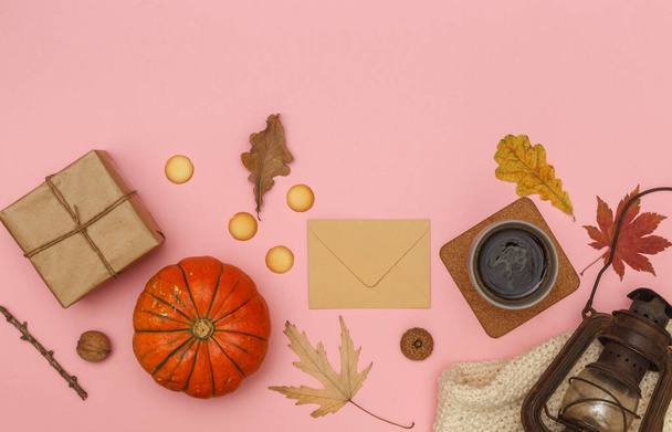 Herbstliches Layout auf rosa Pastell-Hintergrund mit trockenen Blättern, orangefarbenem Kürbis und einem Bastelumschlag. Über den Kopf mit Platz für Text - Foto, Bild