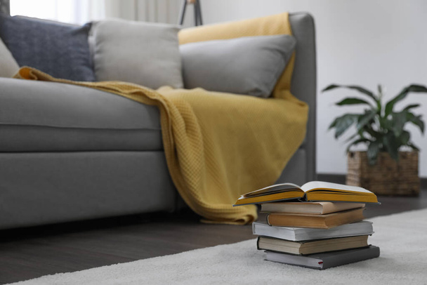Stack of books near sofa in living room. Interior design - Photo, image