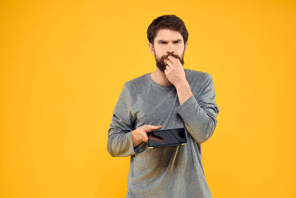 Hombre barbudo con tableta en manos tecnología trabajo dispositivo inalámbrico fondo amarillo - Foto, Imagen