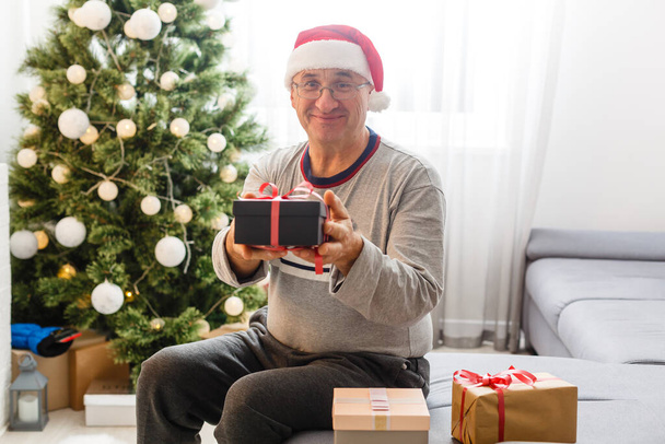 technology, blogging and people concept - happy smiling senior man recording video message or taking picture at home at christmas - Фото, изображение