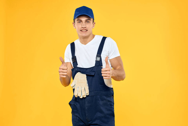 Man in het werken uniforme emoties rendering service delivery service gele achtergrond - Foto, afbeelding