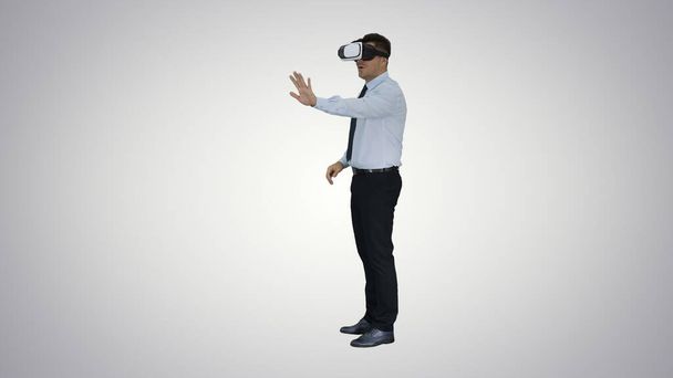 Businessman in virtual reality headset walking in virtual world - Valokuva, kuva