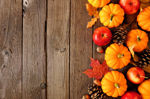 カボチャ、葉、リンゴと秋のサイドボーダー。コピースペースのある素朴な暗い木の背景の上のビュー. - 写真・画像