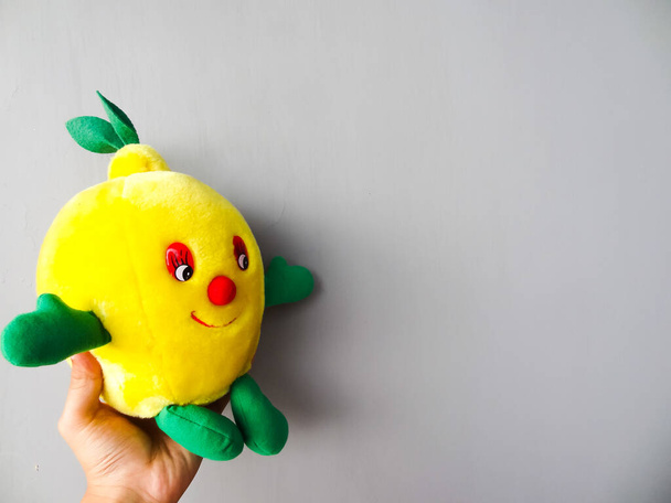 жовта фруктова лялька на сірому фоні
 - Фото, зображення