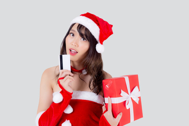 Чудовий портрет молодої азійської жінки, яка має кредитну картку і червону скриньку на різдвяних святах ізольовані на білому фоні, красуня Азія несподівана покупка з кредитною карткою в день xmas. - Фото, зображення