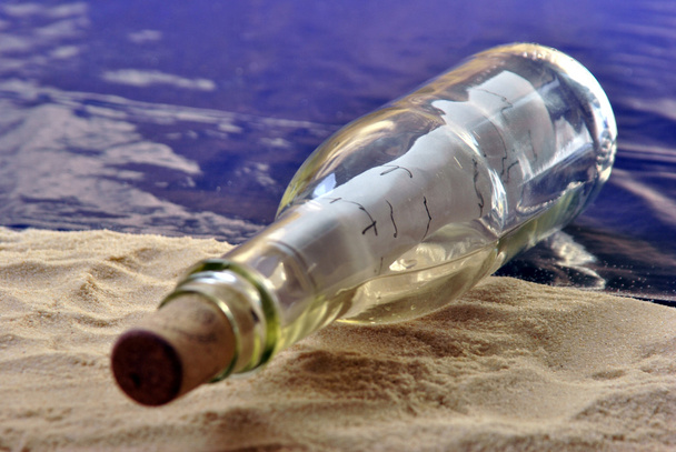 Bottle message on a sandy beach with a letter - Foto, imagen