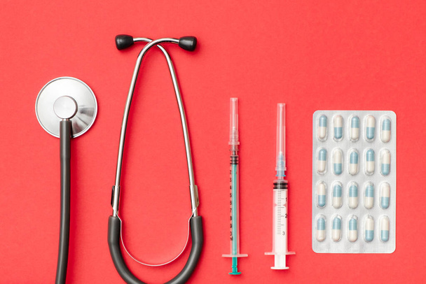 Top view of doctor's table with stethoscope and other equipment. Colored background. Top view. Flat lay - 写真・画像