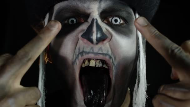 Hombre siniestro con maquillaje de cráneo haciendo caras y mostrando el dedo medio. Mal gesto. Halloween - Imágenes, Vídeo