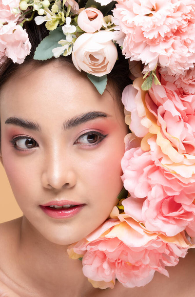 Beauty Asian young woman with big bouquet flowers on head smile with clean fresh skin Happiness and cheerful with positive emotional on Beige background,Beauty Cosmetics and Facial treatment Concept - Фото, зображення