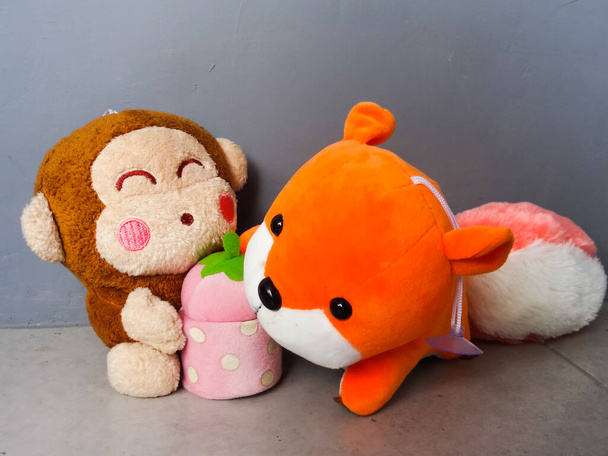 Кукла оранжевой белки и ее подруга на сером фоне - Фото, изображение