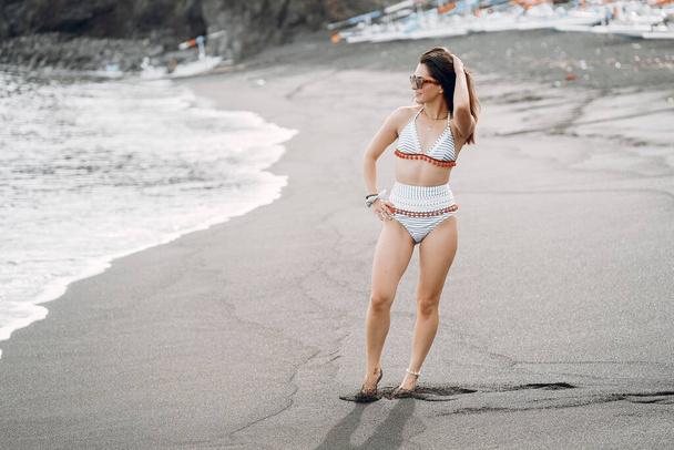 Girl in a stylish swimsuit have a rest n a beach - Фото, зображення