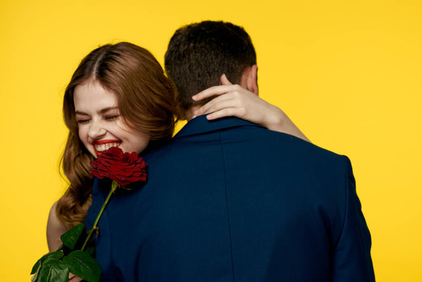 恋人男性女性とともに赤いバラで手ロマンス休日黄色の背景家族の友人. - 写真・画像