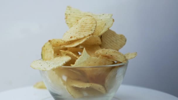 Batatas fritas em uma tigela Batatas fritas em uma tigela de vidro no fundo branco - Filmagem, Vídeo