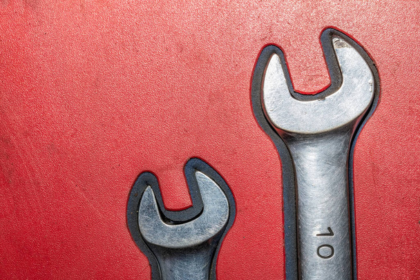 Close-up of two old chrome wrenches on red background. - Fotoğraf, Görsel