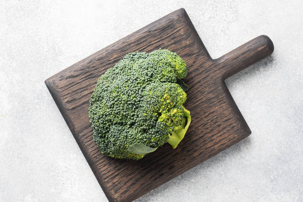 Fresh head of broccoli cut on a cutting Board on grey concrete table. Copy space - Photo, image