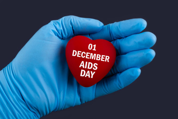 Doctor in blue gloves holds a heart with text 01 December Aids Day, concept. - Fotoğraf, Görsel