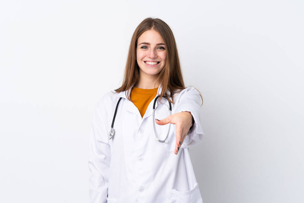 Mladá žena na izolovaném pozadí v doktorských šatech a se stetoskopem dělat dohodu - Fotografie, Obrázek
