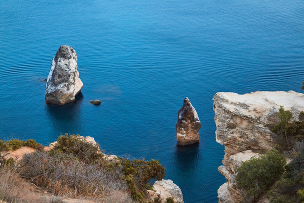 Nature landscape, summer time and panoramic view idea. Stones in calm blue sea. Trail of floating yacht on ocean water. - Φωτογραφία, εικόνα