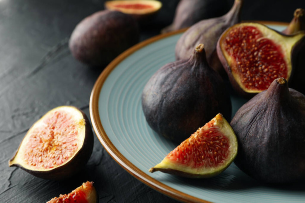 Plate with fig on black background, close up - Photo, Image