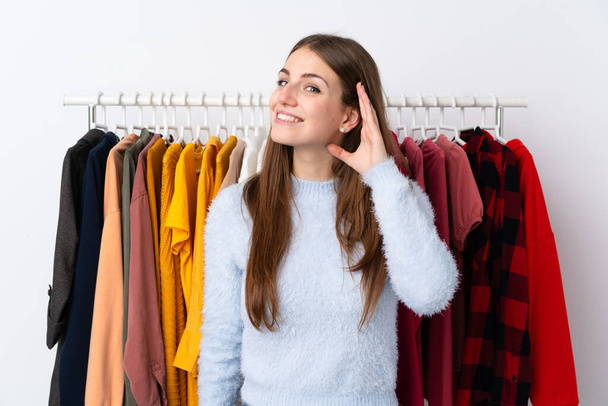 Молодая женщина в магазине одежды слушает что-то - Фото, изображение