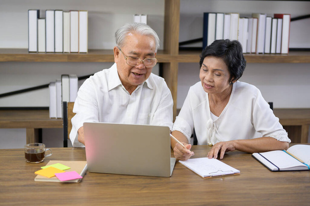 A happy senior Asian couple is spending time on surfing  the internet and talking with family on webcam,  retirement concept. - Photo, Image