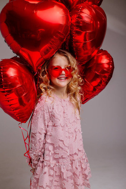 blond little girl in pink dress with red balloons  - Foto, Imagem