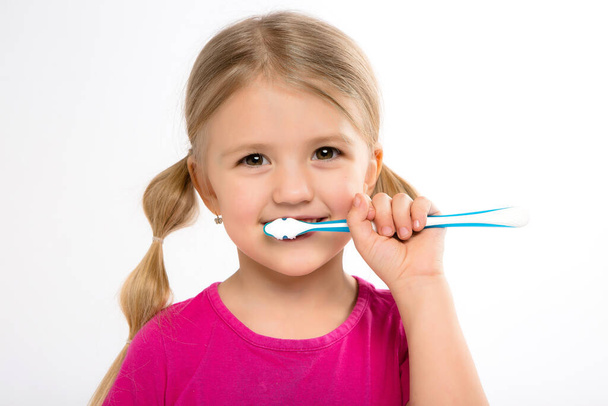 schattig blond meisje met tandenborstel  - Foto, afbeelding