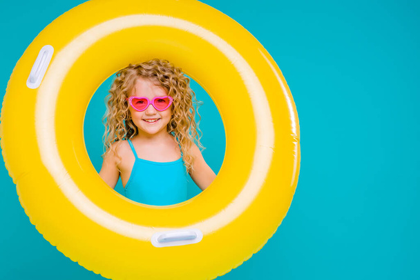 cute little girl with yellow pool inflatable  - Фото, изображение