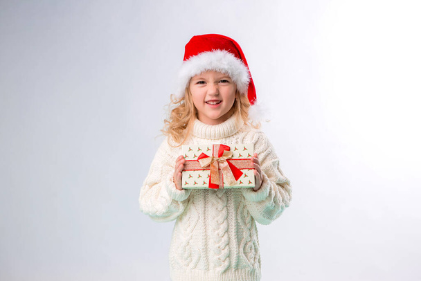 niña en jersey blanco con regalo, concepto de Navidad  - Foto, imagen