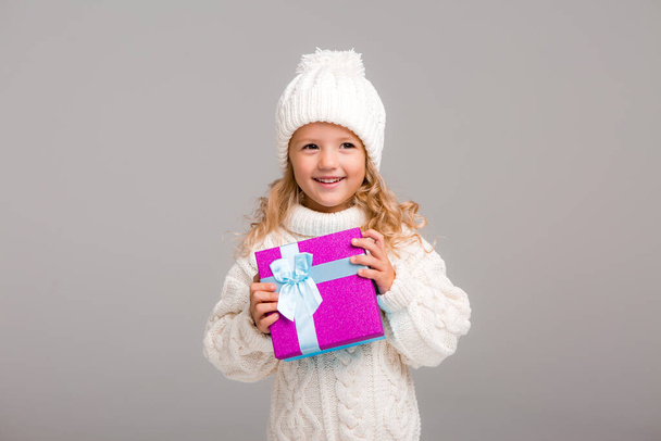 little girl in white sweater with gift - Photo, Image