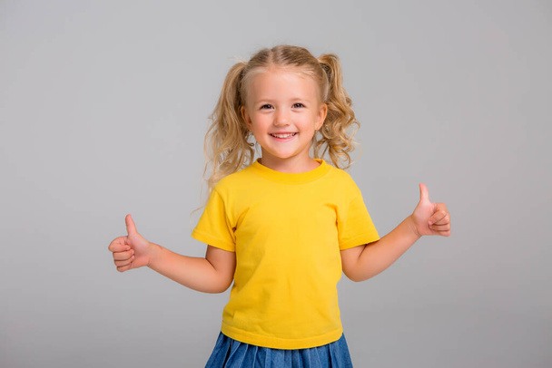  blond little girl in yellow shirt  - Фото, изображение