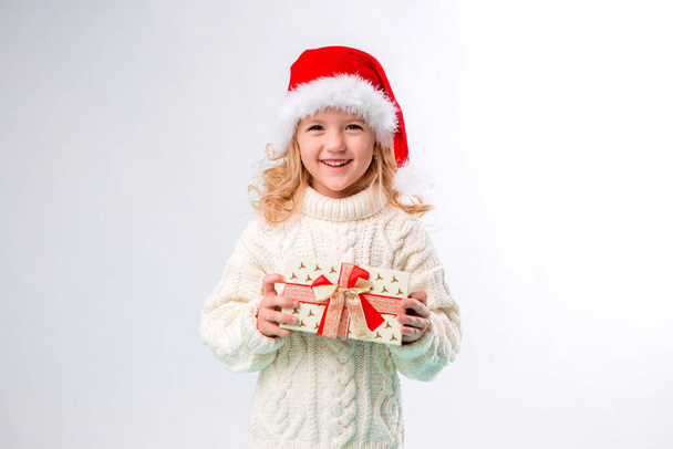 dziewczynka w białym swetrze z prezentem, koncepcja Bożego Narodzenia  - Zdjęcie, obraz