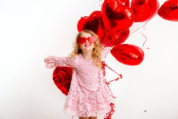 menina loira em vestido rosa com balões vermelhos  - Foto, Imagem