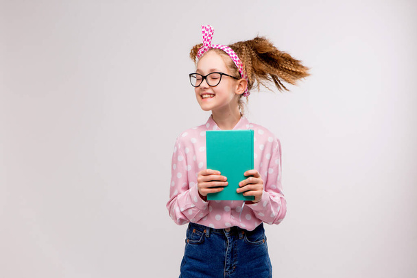 cute school girl with book posing in studio  - Fotó, kép