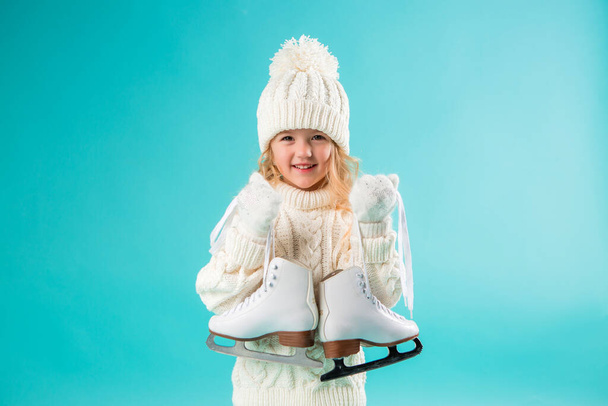 dziewczynka w białym swetrze z łyżwami - Zdjęcie, obraz
