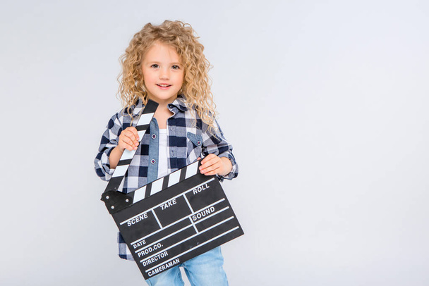 söpö pieni onnellinen tyttö poseeraa studiossa leikkuri  - Valokuva, kuva