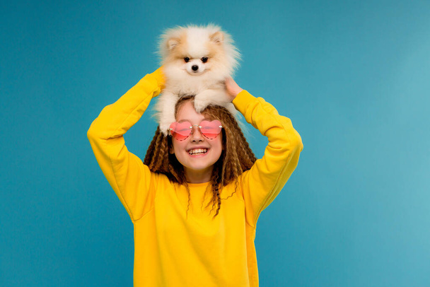 aranyos kislány napszemüvegben vicces kis kutya  - Fotó, kép