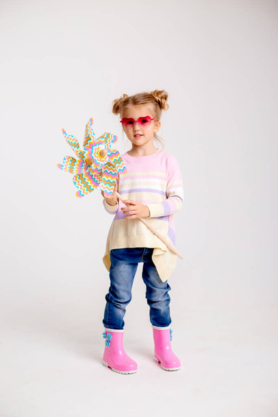 мила маленька дівчинка з іграшкою вітряної млини
 - Фото, зображення