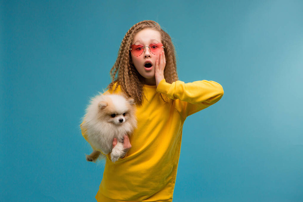 słodkie dziewczynka w okulary przeciwsłoneczne z zabawny mały pies  - Zdjęcie, obraz
