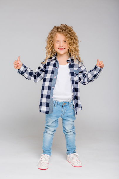 cute little girl in studio with thumbs up  - Photo, image