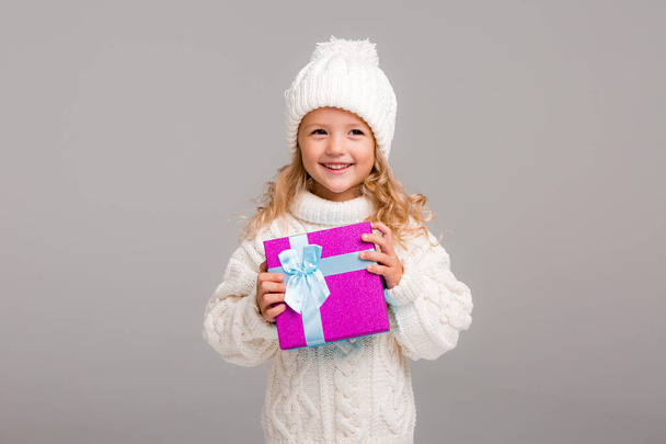 Beyaz kazaklı, hediyeli küçük kız - Fotoğraf, Görsel