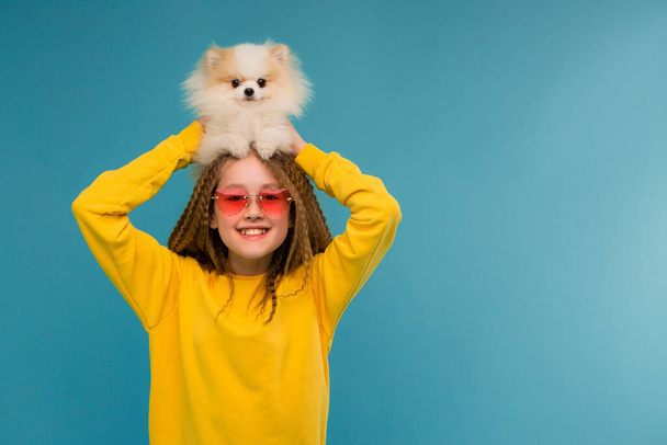 χαριτωμένο κοριτσάκι με γυαλιά ηλίου με αστείο σκυλάκι  - Φωτογραφία, εικόνα