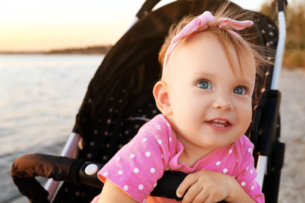 川の近くのベビーカーでかわいい赤ちゃん - 写真・画像